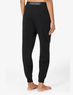 Calvin Klein Reimagined Logo-band Relaxed-fit Mid-rise Cotton-recycled Polyester Blend Jogging Bottoms 10 Calvin Klein Reimagined Logo-band Relaxed-fit Mid-rise Cotton-recycled Polyester Blend Jogging Bottoms -Sweaty Betty Store R03875729 BLACK ALT03