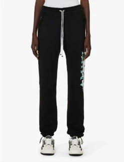 Amiri Floral Logo-print Tapered Cotton Jogging Bottoms 9 Amiri Floral Logo-print Tapered Cotton Jogging Bottoms -Sweaty Betty Store R04191415 BLACK ALT02
